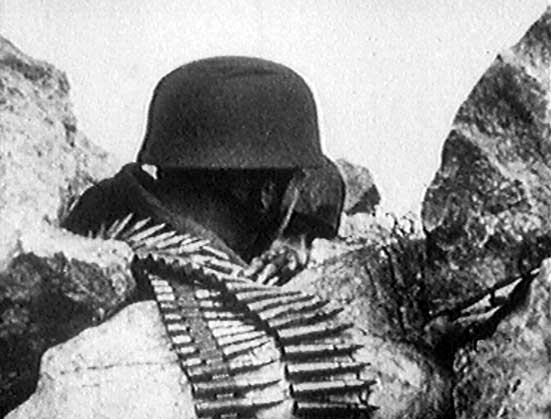 <p>Con un nastro di colpi 7.92mm, un paracadutista è in posizione tra le rocce di Monte Cassino.</p>