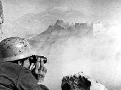 <p>Un paracadutista tedesco osserva il Monastero dallo Snakeshead Ridge dopo il bombardamento.</p><p class='eng'>Die Deutsche Wochenschau Nr 711 April 19, 1944 (min. 9:50).</p>