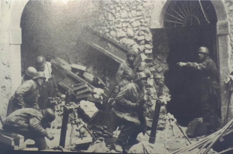 <p>1944, una postazione di paracadutisti tedeschi tra le rovine di Cassino. Uno di loro porta l'elmetto Mod. 35 con l'emblema nazionale.</p><p class='eng'>Bild 101I-577-1921-33. Foto: Zscheile 1943 (?)</p>