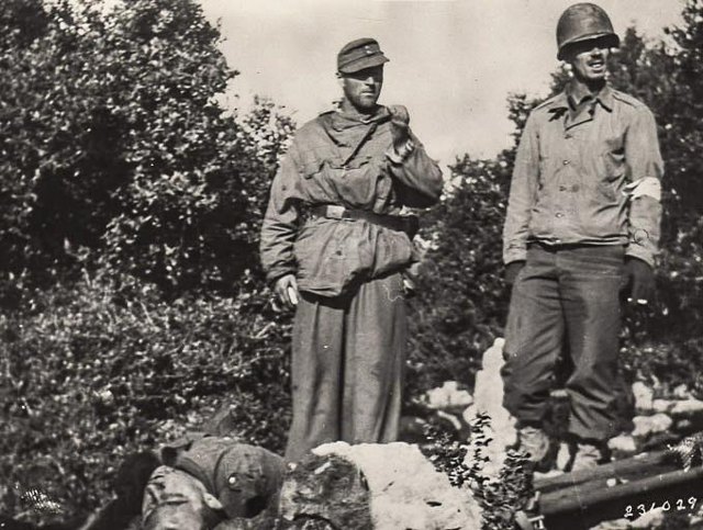 <p>Cassino, Monte Castellone, 14 febbraio 1944. Un barelliere tedesco con un barelliere americano durante la tregua nei combattimenti; si noti a terra un caduto tedesco.</p><p class='eng'>SC-111-236029</p>