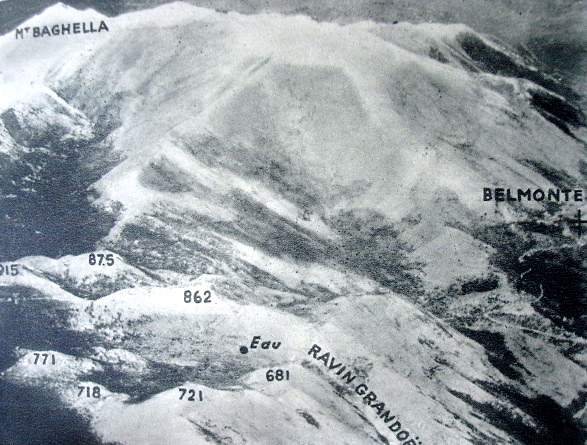 <p>Una veduta aerea della zona del Belvedere, ripresa il 24 gennaio 1944. Si notano bene la forma a ferro di cavallo delle cime che contornano il Belvedere ed il pianoro dell'Ottaduna, il Ravin Gandoet ed il pozzo d'acqua tanto conteso durante i combattimenti.</p>