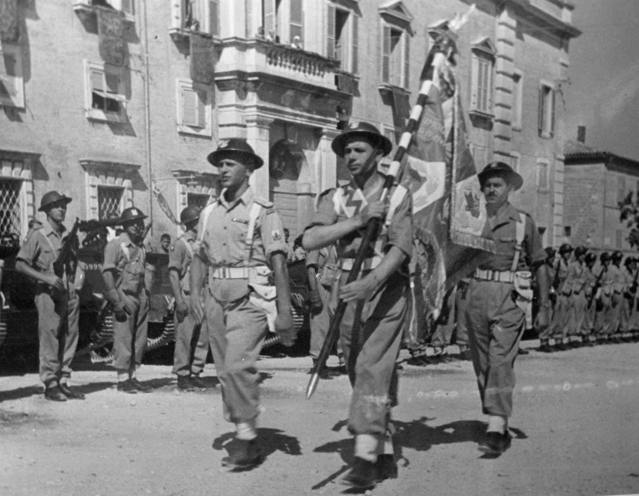 <p>Imola, 11 agosto 1946, sfila la bandiera dell!8° battaglione della 3a divisione dei Carpazi, donata dalla popolazione.</p><p class='eng'>Imola, 11th August 1946, the flag of the 8th Battalion, 3rd Carpathian Infantry Division, conferred by the Town's Citizens.</p>