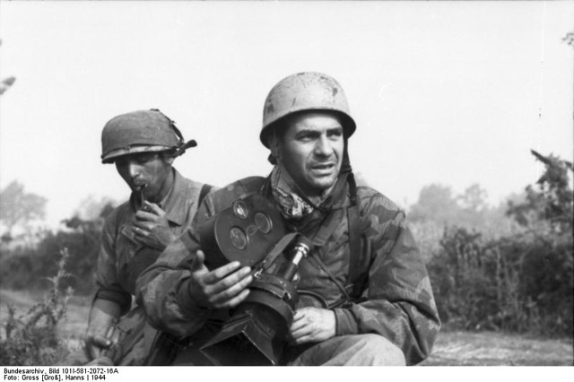 <p>Italia 1944, paracadutisti tedeschi con l'elmetto mimetizzato.</p><p class='eng'>Italy 1944, German Paratroopers with the camo paint helmet.</p><p class='eng'>Bundesarchiv_Bild_101I-581-2072-16A,_Italien,_Fallschirmjäger,_einer_mit_Filmkamera.</p>