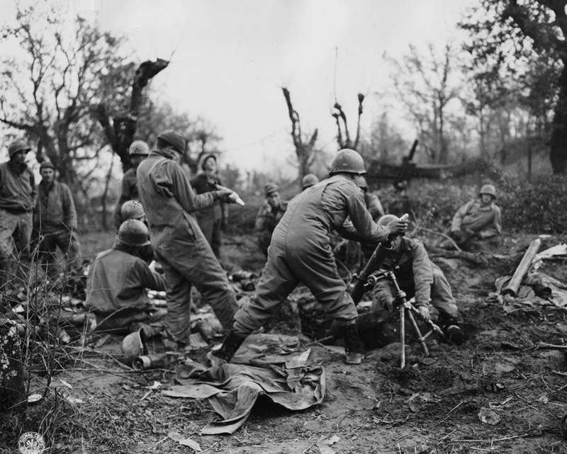 <p class='eng'>28 Jan 1944 – Fifth Army, Rapido River Area, Italy – Pounding German positions in the Rapido River area. Infantrymen load an 81mm mortar shooting at enemy emplacements while other members of the crew hold shells for loading. (U.S. Army Signal Corps photo – 163d Signal Photo Co.)</p>