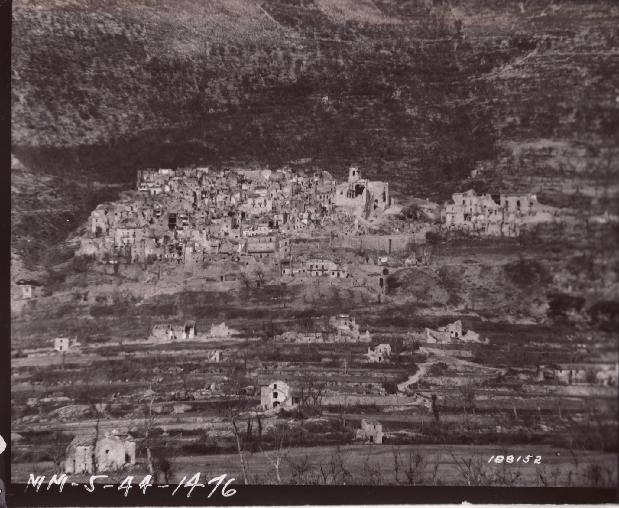 <p class='eng'>San Pietro reduced to ruins, December 1943. The eviscerated church of St. Michael the Archangel can be seen looming over other buildings in the village.</p>