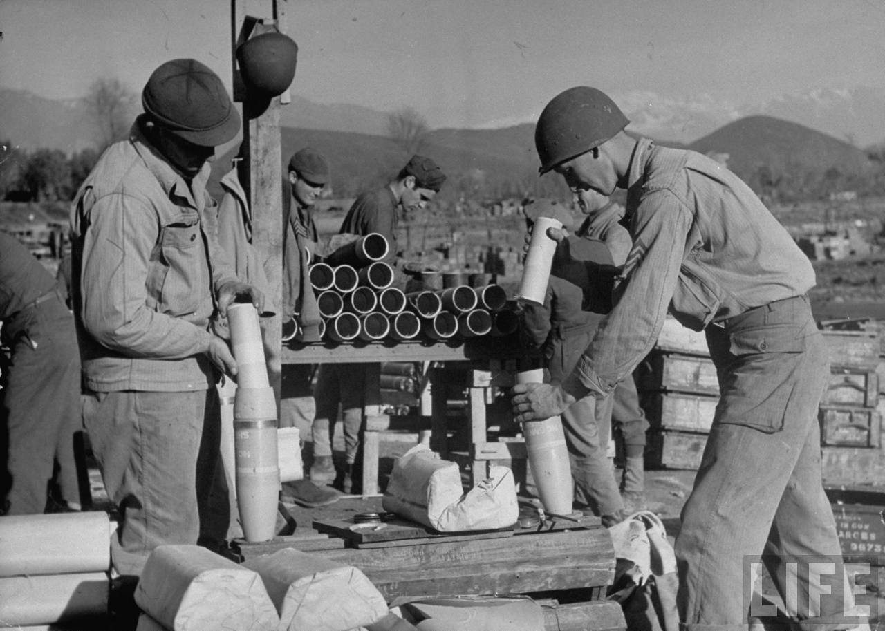 <p class='eng'>Amer. soldiers loading propaganda leaflets into smoke shells after the smoke candles have been removed & only gun powder is left so they can be shot across enemy lines at dusk for German soldiers to read, in the Cassino corridor of battle.</p>