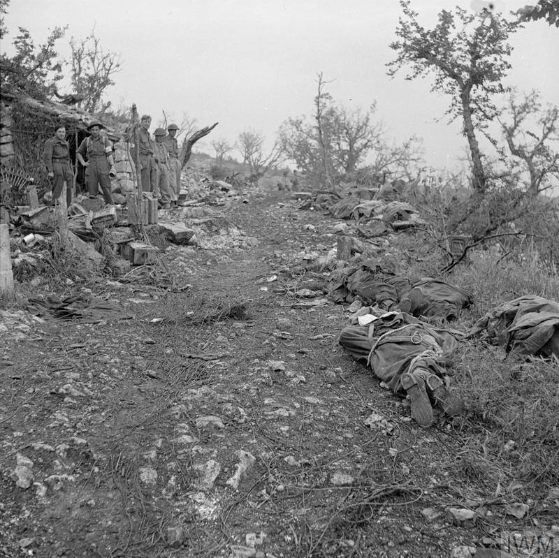 <p>Maggio 1944. I corpi dei caduti polacchi raccolti presso la "Casa del Dottore" in attesa di sepoltura.</p><p class='eng'>Dead soldiers of the 2nd Brigade, 3rd Carpathian Rifles Division (2nd Polish Corps) lying by the 3rd Division's Advanced Dressing Station, so called 'Domek Doktora' - 'Doctor's House', after the last battle of Monte Cassino, 19 May 1944. © IWM NA 15139</p>