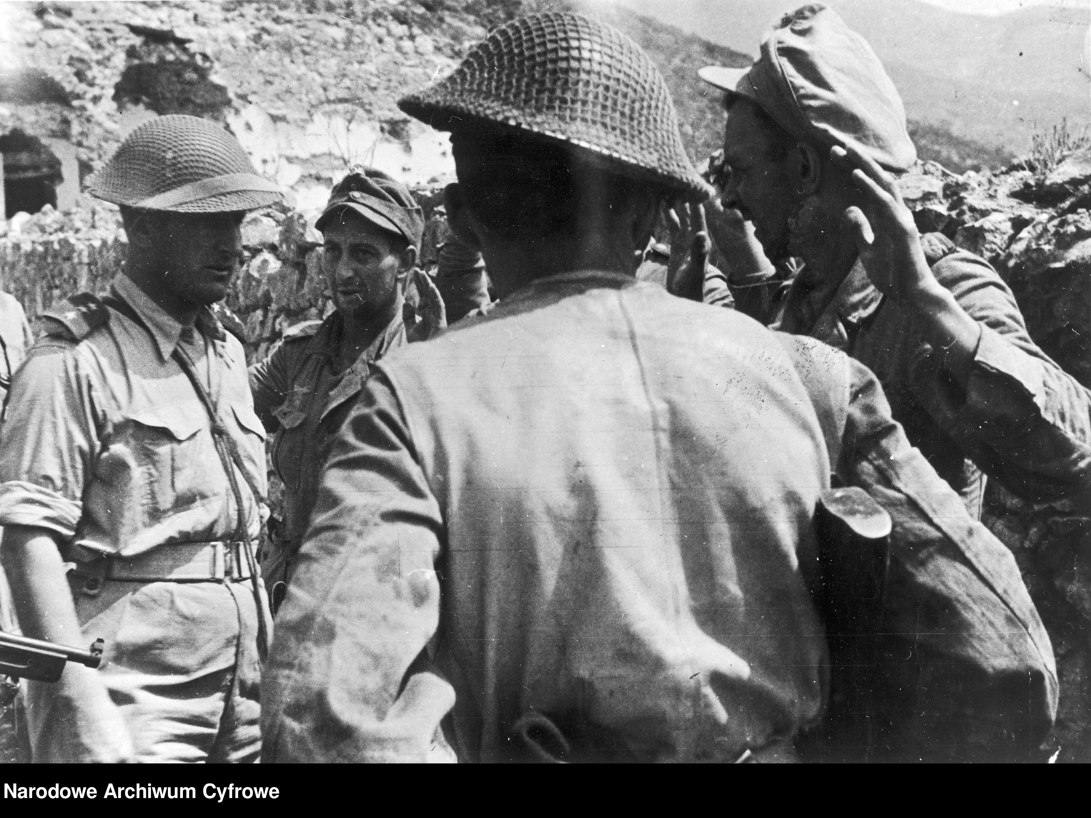 <p class='eng'>1944/05/25<br />Capt. Weiss (1st from the left) interrogates German prisoners of war pulled out of the buried bunker.<br />NAC 3/24/0/-/457/11</p>