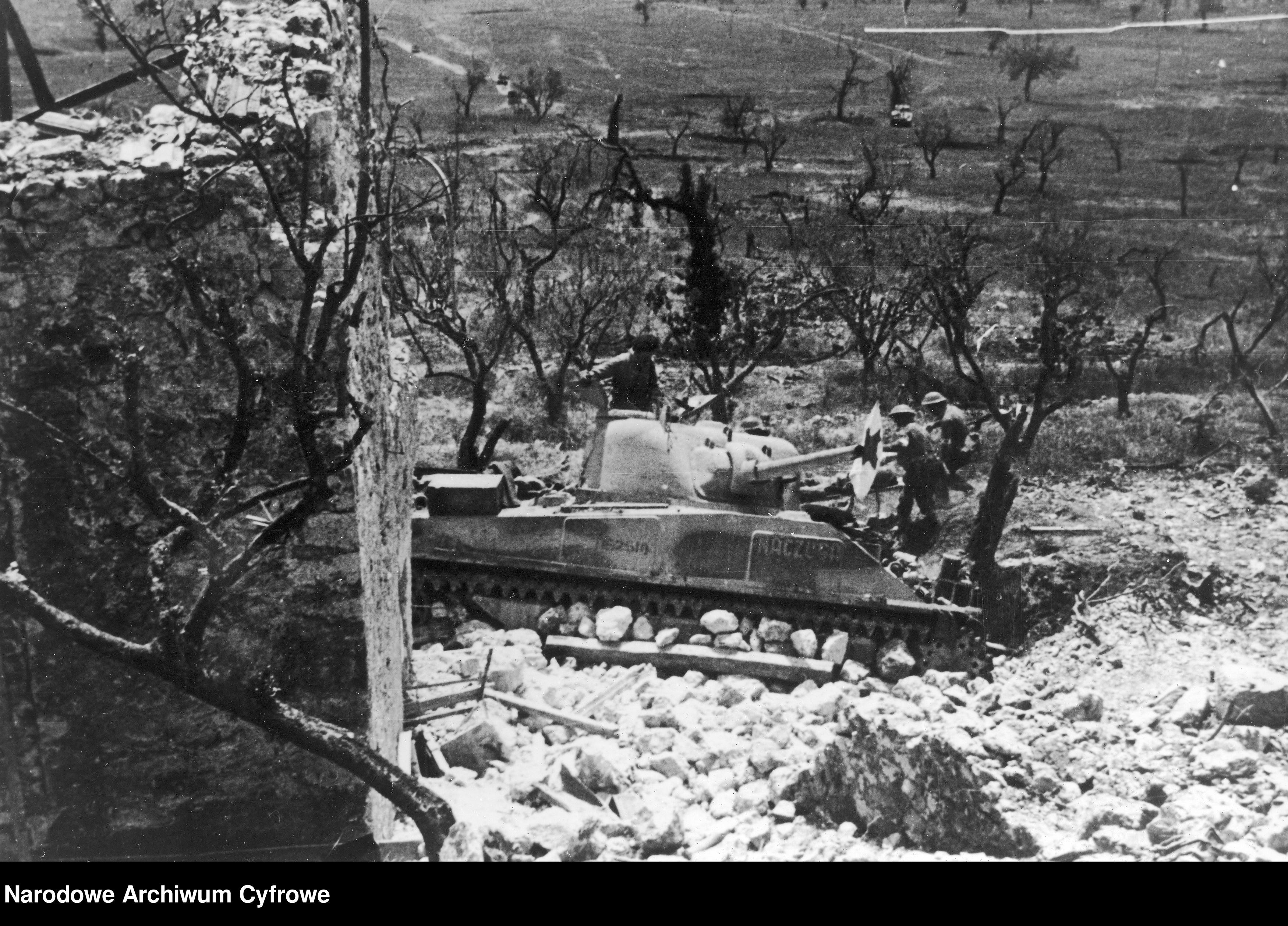 <p class='eng'>1944/05<br />Paramedics are carrying a heavy wounded soldier under the cover of the M4 Sherman "Maczuga" tank from the 2nd Independent Armored Brigade.<br />NAC 3/24/0/-/457/19</p>